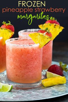 two glasses filled with watermelon and pineapple drink next to sliced strawberries