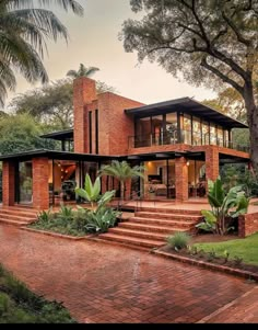 a large brick house surrounded by lush green trees