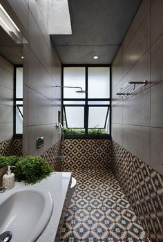 a bathroom with tiled walls and flooring next to a white sink under a window