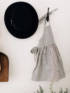 a black hat hanging on a wall next to a cutting board