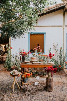 a table with flowers on it in front of a house