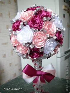 a bouquet of pink, white and red roses in a vase on a kitchen counter