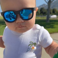 Whether hiding from the paparazzi or the sun, our baby sunglasses have you covered! Polarized and sized to fit ages 0-2 years, these shades protect baby from 100% of UV rays. Flexible rubber frames and shatter-proof flenses mean these babies are ready to withstand some good old fashioned wear and tear. Oh, and did we mention, they are absolutely adorable?! Babiators Blue series have mirrored lenses and come with a felt case and silicone strap to keep them in place (pink and black model only) Dur Flower Girl Sunglasses, Free Baby Books, Personalized Kids Sunglasses, Trendy Flower-shaped Tinted Sunglasses, Trendy Baby Gifts, Baby Sunglasses, Felt Case, Airplane Baby, Baby Sun Hat