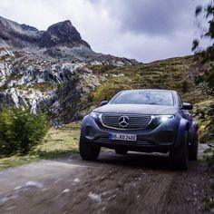 a car driving down a dirt road in the mountains