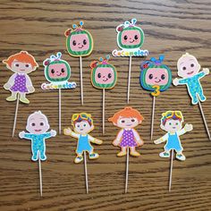 there are many cupcake toppers on the stick with children's faces in them