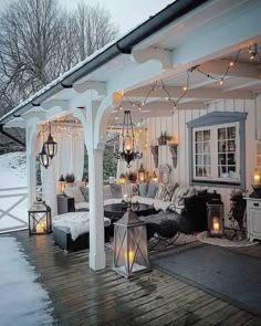 an outdoor covered porch with lights and decorations on the ceiling, along with white furniture