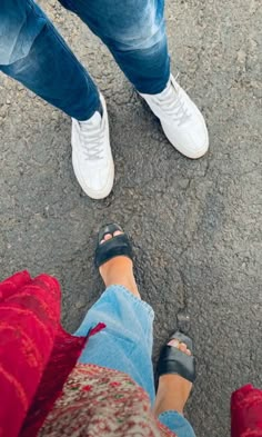 two people standing next to each other with their feet crossed