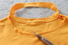 a t - shirt with a needle on it laying on the floor