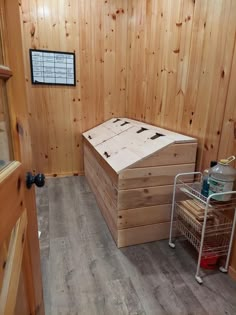 the inside of a cabin with wooden walls and wood flooring, including two storage boxes