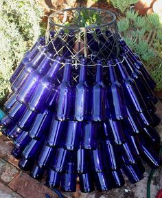 a blue glass vase sitting on top of a brick wall