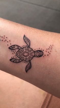 a small tattoo on the arm of a woman's arm with a turtle design