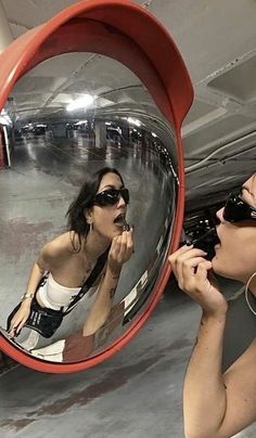 a woman is taking a selfie in front of a large mirror with her reflection