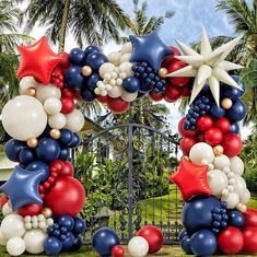 an arch made out of balloons and stars in the shape of fireworks is decorated with red white and blue colors