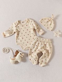 a baby's outfit, hat and toy horse on a white surface