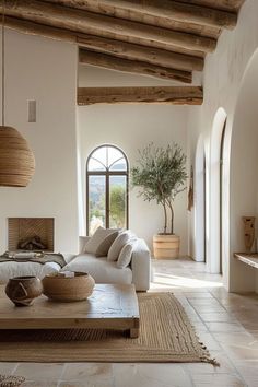 a living room filled with lots of furniture next to a large window covered in wooden beams