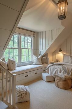 an attic bedroom with white walls and carpeted flooring, built - in storage drawers under the window