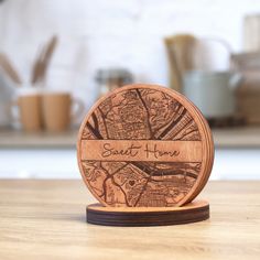 a wooden coaster with the word sweet home engraved on it, sitting on a table