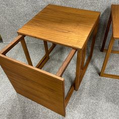 two wooden stools sitting next to each other on top of a carpeted floor