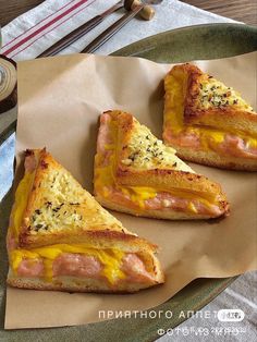 three slices of ham and cheese pizza sitting on top of a piece of wax paper