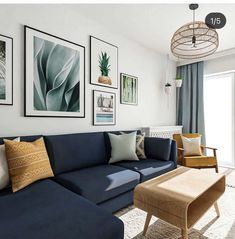 a living room with blue couches and pictures on the wall above them in front of a sliding glass door