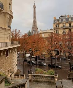 the eiffel tower is seen in the distance from an apartment building on a rainy day