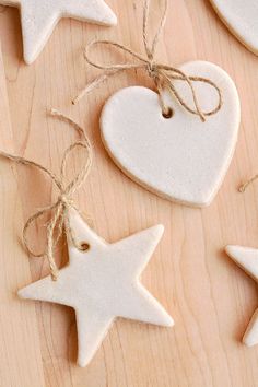 white ceramic ornaments with twine on wooden surface, including heart and star ornament