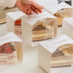 a person is reaching for some desserts in small boxes