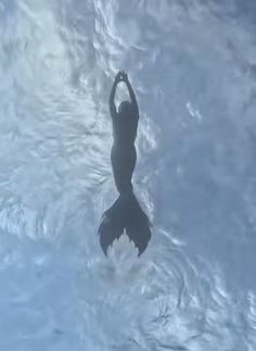 a person in the water with their arms up