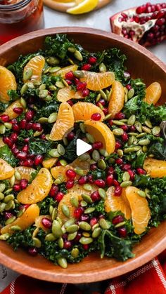 an orange and kale salad with pomegranates in a wooden bowl