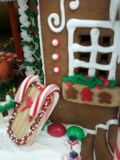 a gingerbread house decorated with candy canes and other holiday decorations, including cookies