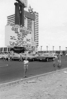 an old black and white photo of people standing in front of a movie marquee