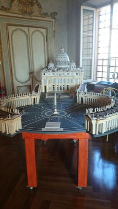 a model of the white house on display in a room with wooden floors and walls