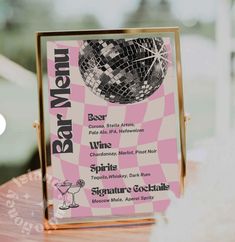 a pink and white menu sitting on top of a wooden table