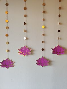 three paper lotus ornaments hanging on a wall