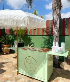 an ice cream stand on the side of a building with palm trees in the background