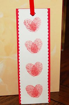 a card with three hearts drawn on it and a red string hanging from the front