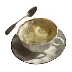 a cup filled with liquid and sliced lemons sitting on top of a saucer