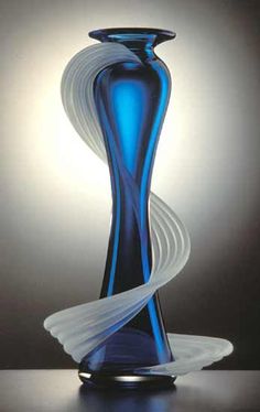 a blue glass vase sitting on top of a table