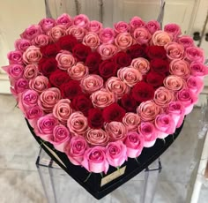 a heart shaped arrangement of pink and red roses