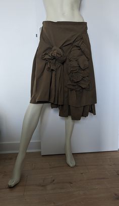 "Year 2002 - Comme des Garçons Asymmetrical wrap skirt in khaki color embellished with large flower bows on the front. Pleats on the back of the skirt. Closes with two buckles on the sides Material: Polyester and cotton Made in japan Size: S Belt: 38cm Back length    61cm   24\" Front length longer part   71 cm   27 3/4\" In very good vintage condition" Comme Des Garcons Skirt, Yohji Yamamoto Street Style, Flower Bows, Pleats Skirt, Rei Kawakubo, Fall Winter Dresses, Fashion Sites, Layering Outfits, Textiles Fashion