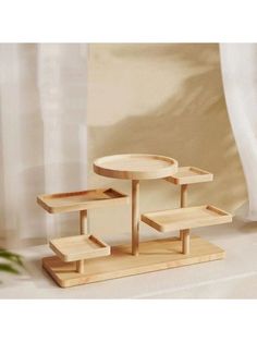 a small wooden table with two shelves on each side and a potted plant in the background