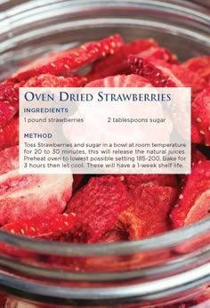 a jar filled with red strawberries next to a label that says oven dried strawberries