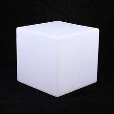 a white cube sitting on top of a black surface