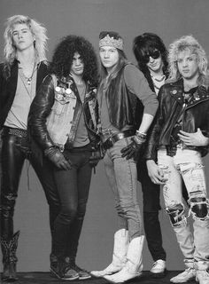 the group of rockers posing for a black and white photo with their leather jackets on