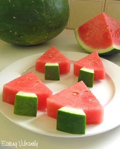 slices of watermelon are arranged on a white plate with green and red squares