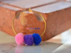 two pom - poms sitting on top of a table next to a piece of wood