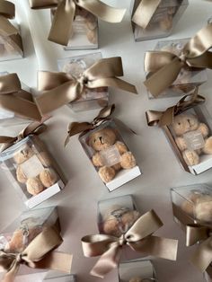 there are many teddy bears in small boxes with bows on them and tied around the edges