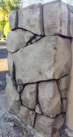 a pile of rocks sitting on the side of a building next to a parking meter