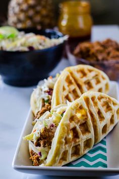 two waffles are sitting on a plate with coleslaw and other food