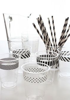 several cups with black and white striped straws in them on a table next to each other